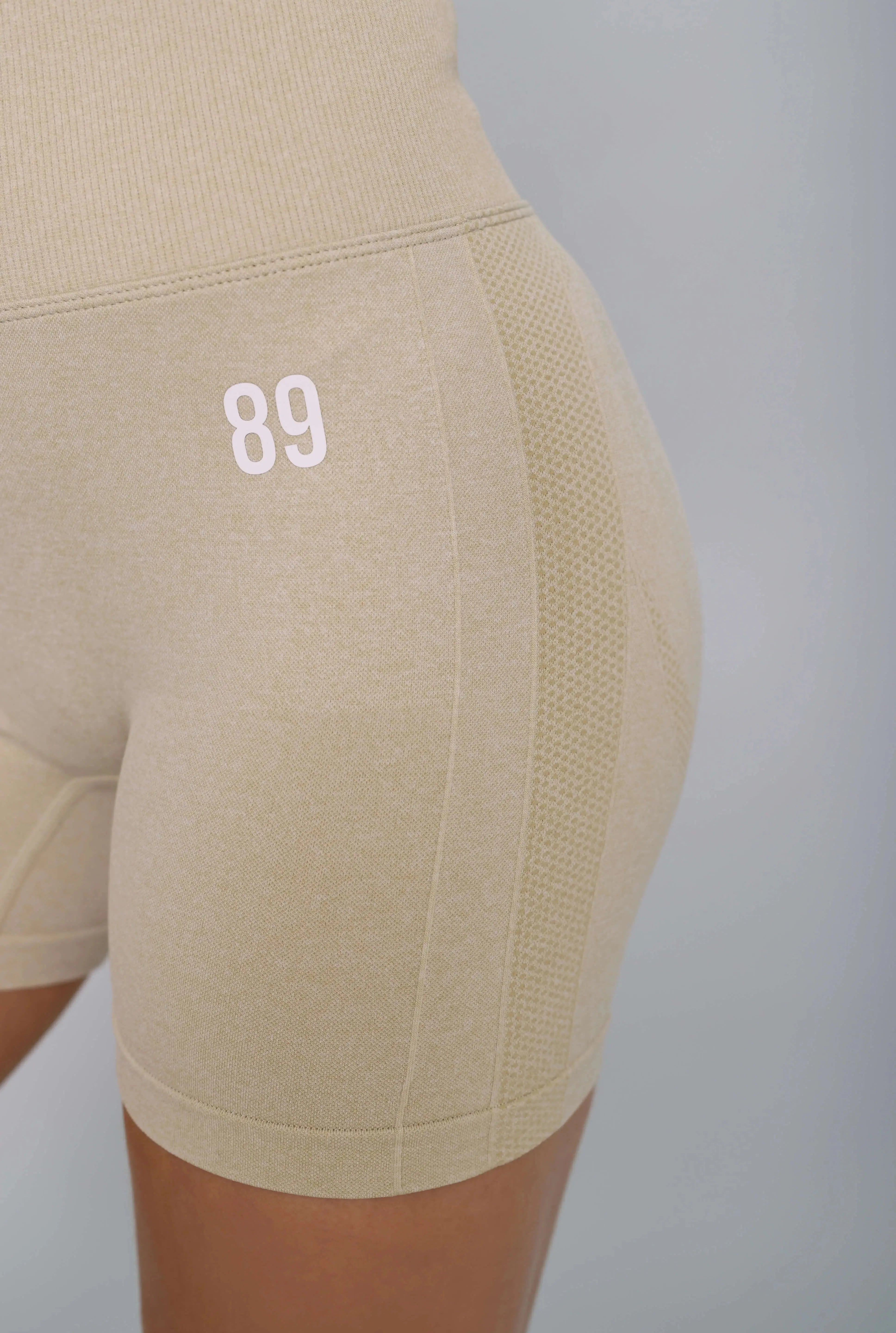 Beige bum scrunch gym shorts – side view, crunch design enhances curves. 