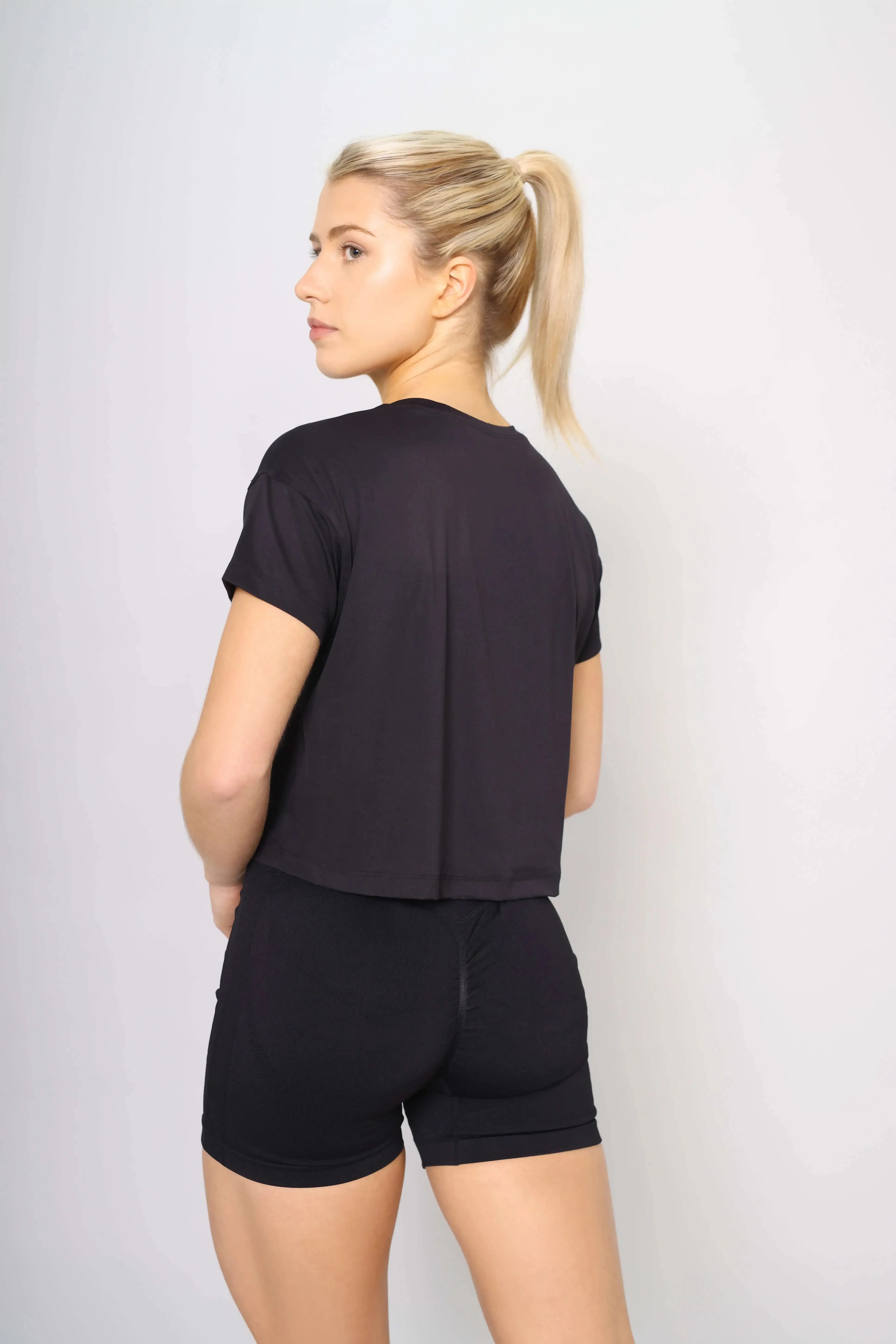 Back view of the black women’s workout crop top