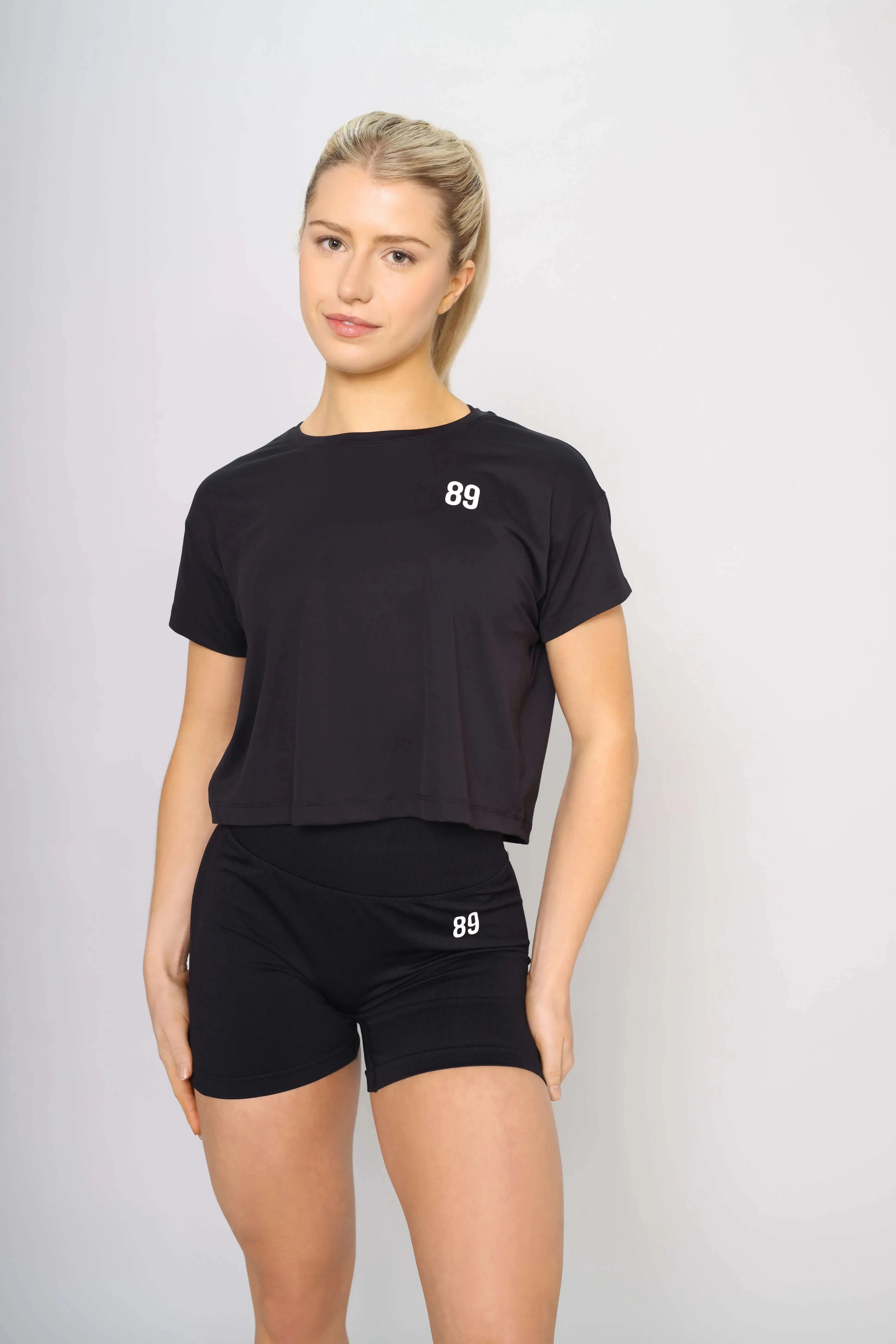 Front view of a classic black workout crop top for women, blending performance with style