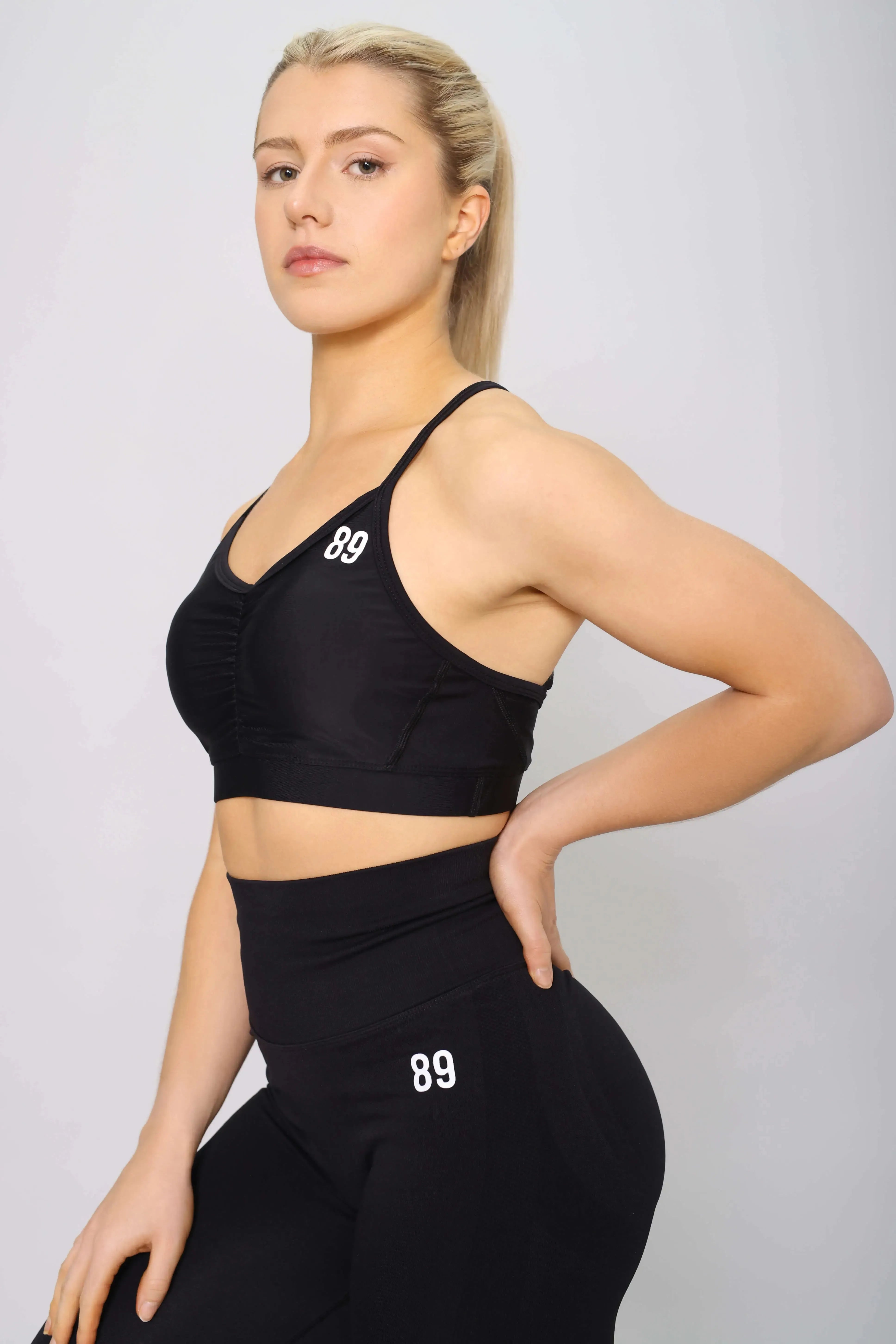 Sports bra with strappy back design in black, side view